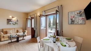 A dining area with a table set for two, a sofa, and a coffee table. - Agriturismo Apart Feltrinelli heated pool, Padenghe sul Garda, Italy (Padenghe sul Garda)