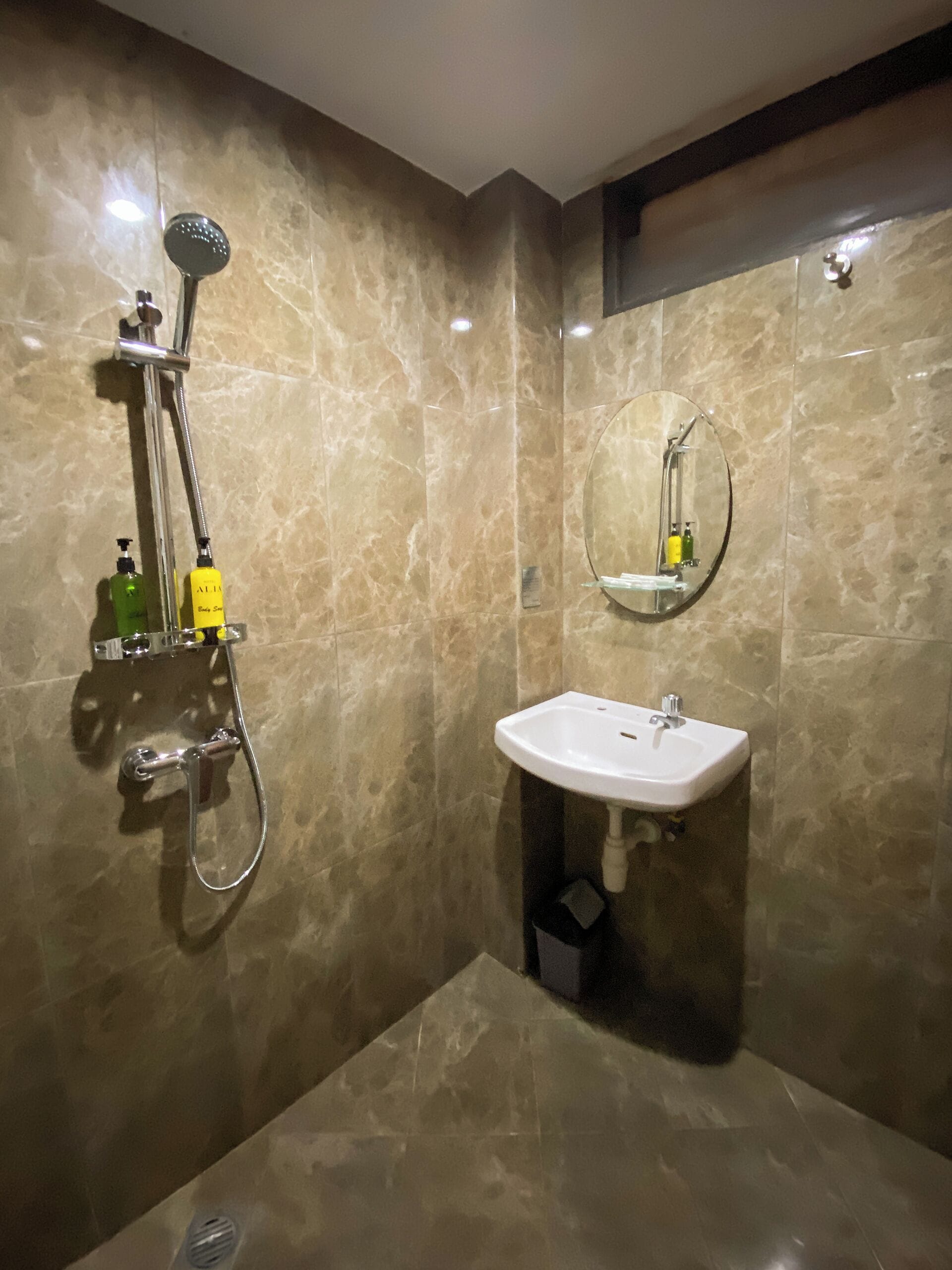 A bathroom with a shower, sink, and mirror.