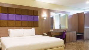 Una habitación de hotel con cama, escritorio y silla.