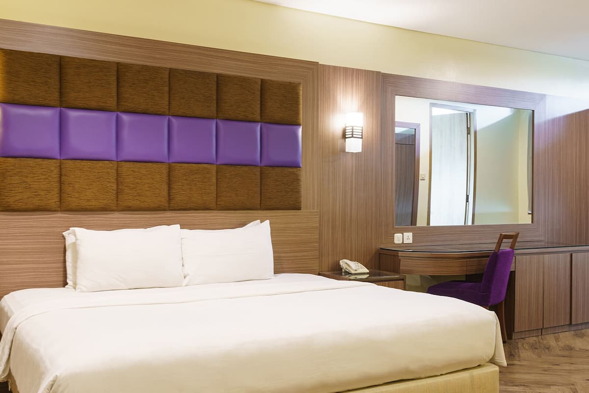Une chambre d’hôtel avec un lit, un bureau et une chaise.