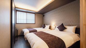A hotel room with two beds, a large window, and a geometric patterned wall.