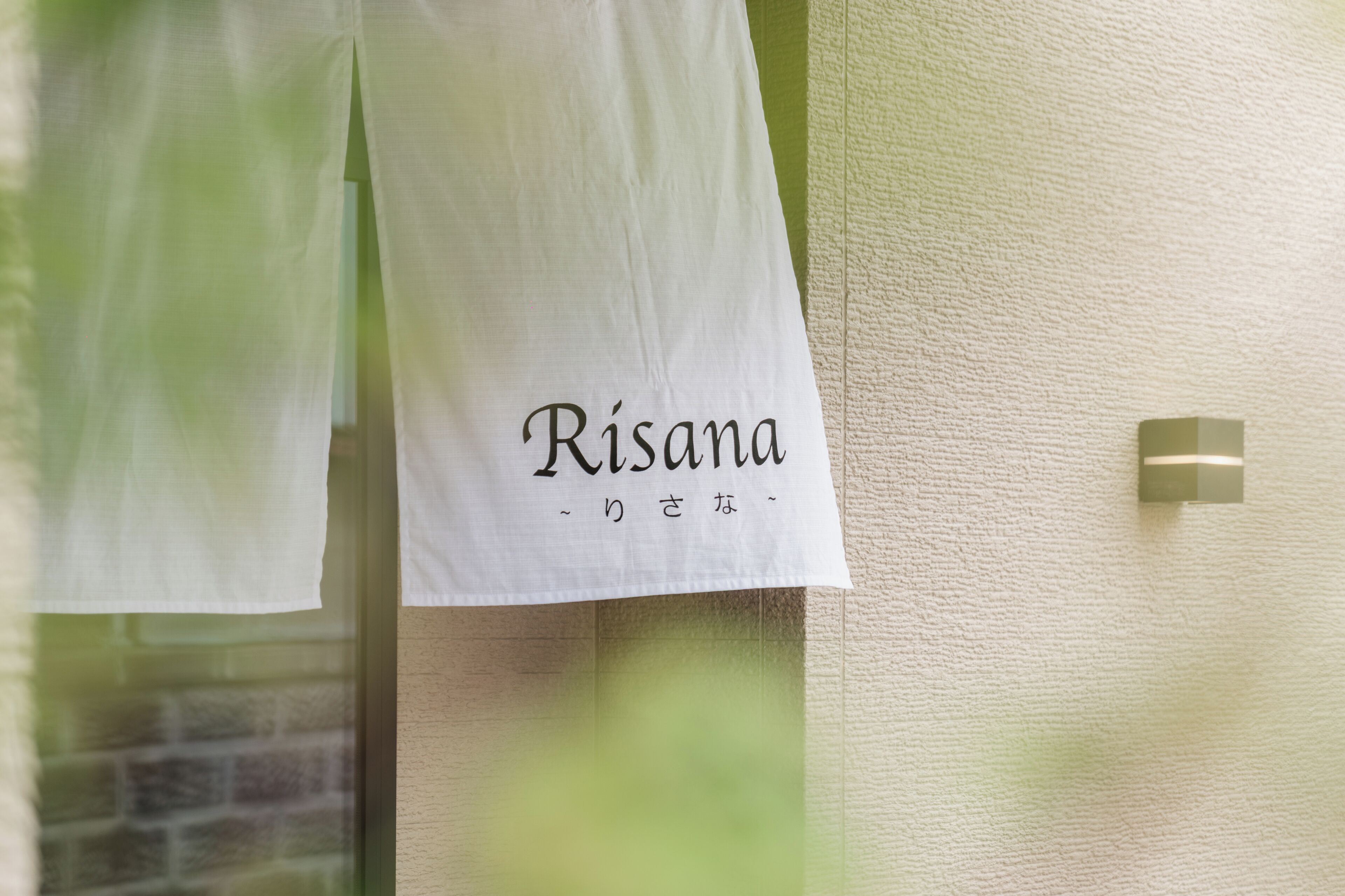 A white sign with the name "Risana" and Japanese characters.