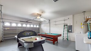 A room with a foosball table, a pool table, and a ceiling fan. - 15 Min to Disney | Spacious 4BR Home w/ Pool (Kissimmee)