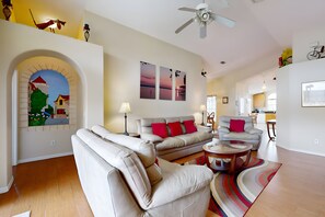 A modern living room with a sofa set, a coffee table, and a ceiling fan.