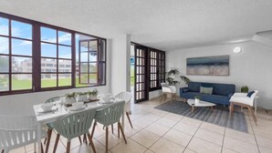 Ein modernes Wohnzimmer mit Essbereich, großen Fenstern und Blick ins Freie.