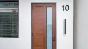 Una porta in legno con un vetro, una targa con il numero 10 e una finestra con persiane.