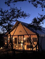 Una carpa grande y bien iluminada, con un área de comedor visible en su interior.