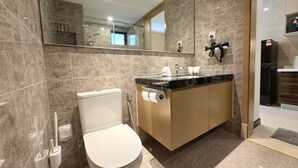 Ein modernes Badezimmer mit Toilette, Waschbecken und Spiegel.