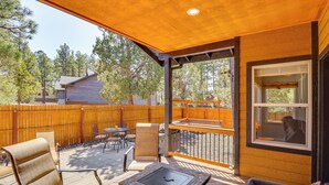 Una veranda coperta con posti a sedere all'aperto, un barbecue e vista sul giardino.
