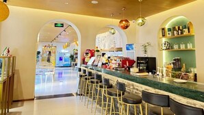 A modern bar area with a long counter and multiple stools. - 18HOW Qianmen Grape Courtyard Hotel (Beijing)