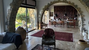 A spacious living area with a stone archway, a dining area, and a view of the outdoors. - Exceptional, charming home in coastal Provence, 5 minutes from the beaches (Sanary Sur Mer)