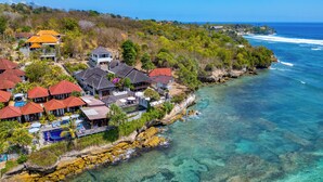 A coastal resort with multiple buildings, a swimming pool, and clear blue waters. - Villa Cemara  (Ceningan Island)