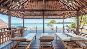 A wooden deck with lounge chairs and a view of the ocean. - Villa Cemara  (Ceningan Island)