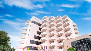 Un edificio de varios pisos con balcones y un letrero que indica que es un hotel.