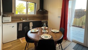 Une cuisine compacte comprenant un coin repas, un four à micro-ondes encastré, un évier et une fenêtre donnant sur l’extérieur.