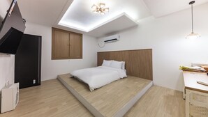 Une chambre moderne avec une lucarne, un lit, un bureau et une armoire.