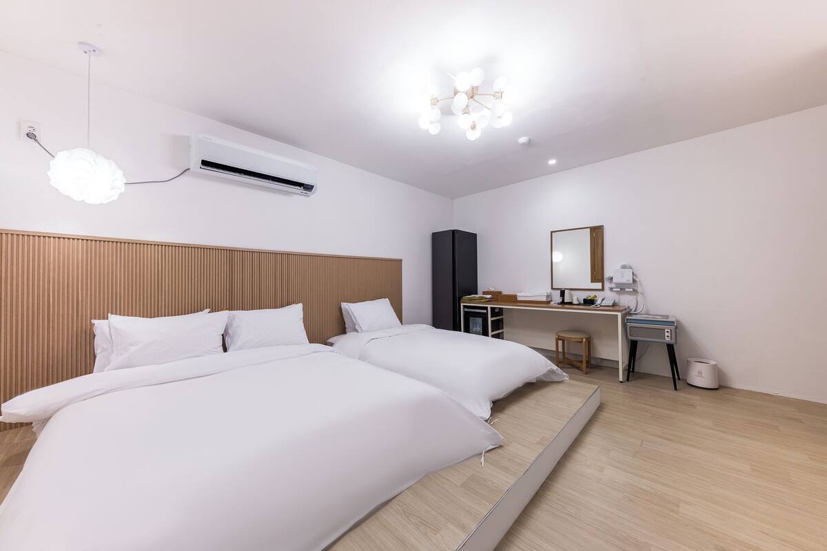 Ein modernes Hotelzimmer mit einem großen Bett, einem Schreibtisch und einem Spiegel.