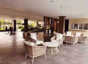 Relax in a stylish indoor space with wicker chairs and a central table, surrounded by natural views.