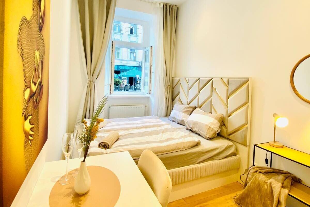 A modern bedroom with a bed, a desk, and a window with curtains.