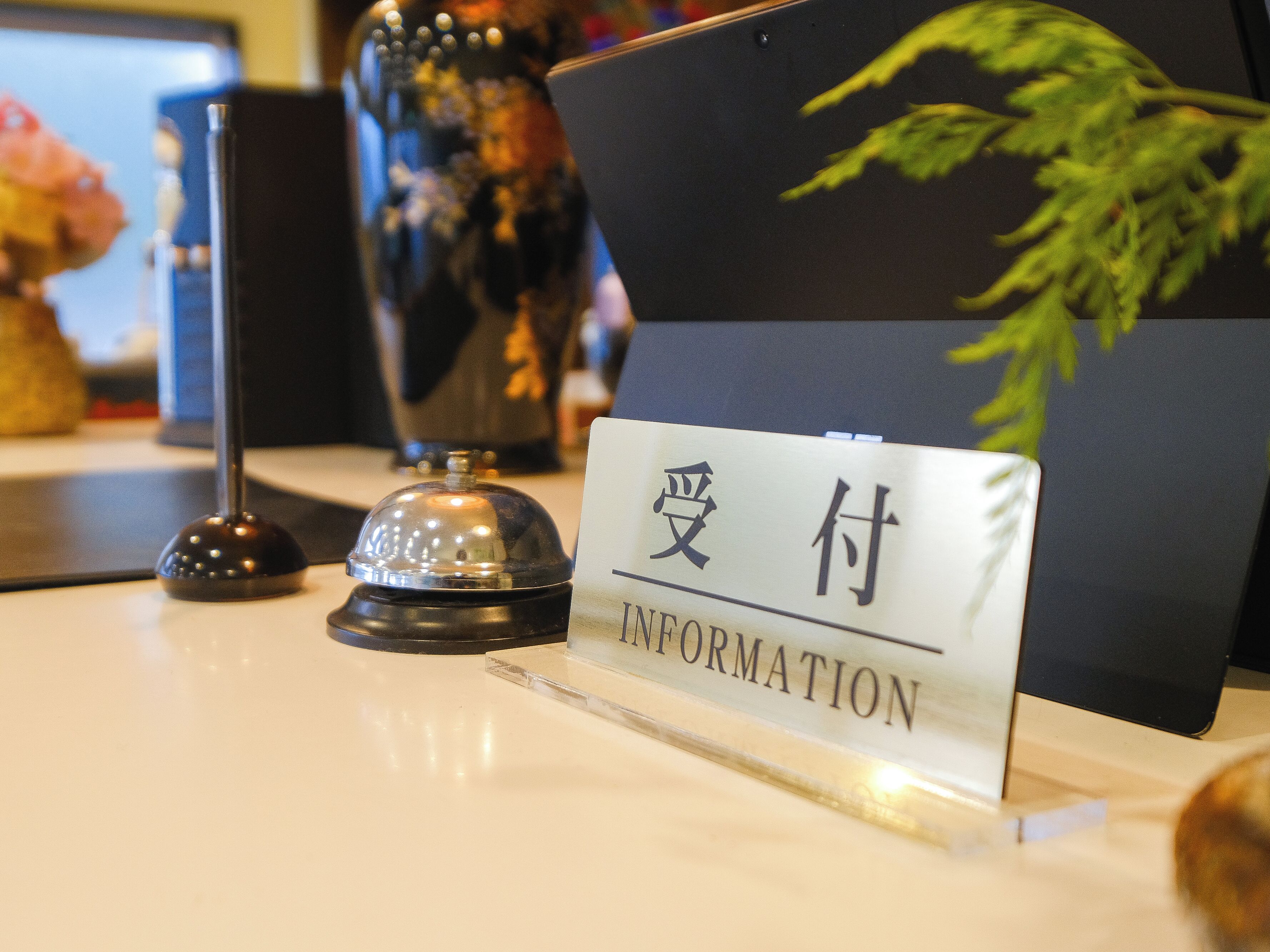 Un mostrador de recepción con un cartel que dice 'Information' en inglés y otro idioma.