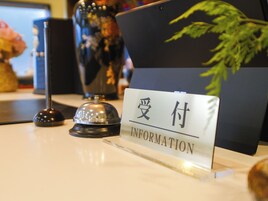Un mostrador de recepción con un cartel que dice 'Information' en inglés y otro idioma.