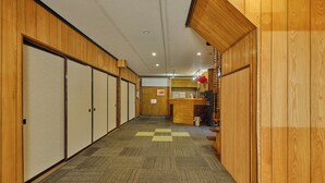 Ein Hotelkorridor mit Holzvertäfelung, einer Rezeption und einer Mikrowelle.