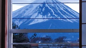 Blick auf den Fuji durch ein Fenster mit horizontalen Jalousien.