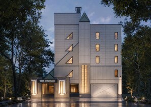 Un edificio moderno con techo plano, múltiples ventanas y un letrero que dice 'THE WADANO'.