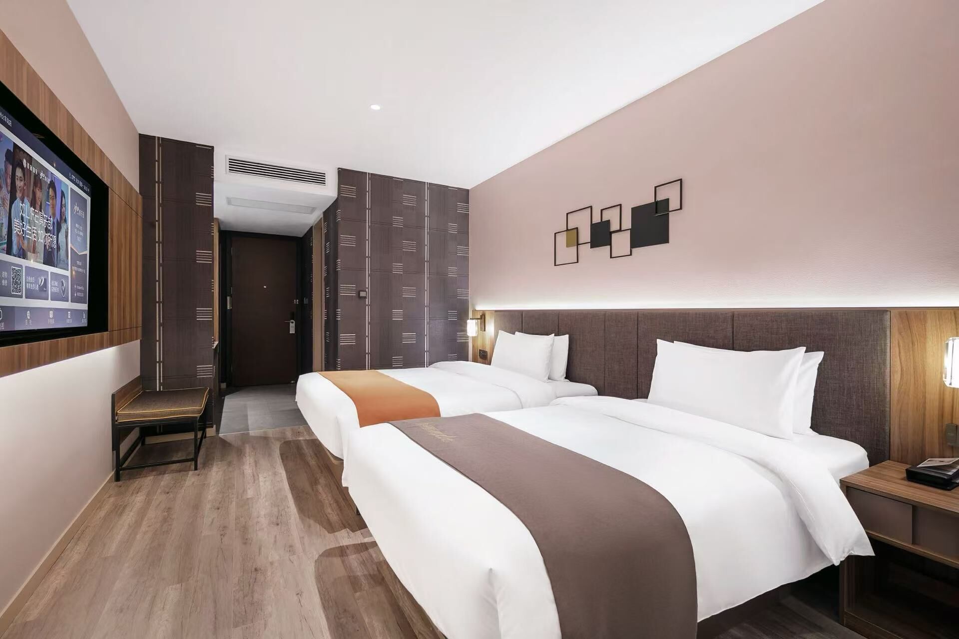 Une chambre d’hôtel avec deux lits, une télévision, un bureau et une armoire.