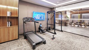 Ein moderner Fitnessraum mit Laufband, Ergometer und Krafttrainingsgeräten.