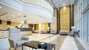 A spacious lobby with a reception desk, seating area, and a decorative wall. - Hotel SDU Boutique Al Madinah (Madinah)