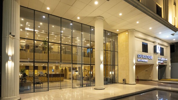A hotel lobby with a reception desk, seating area, and a glass facade. - Hotel SDU Boutique Al Madinah (Madinah)