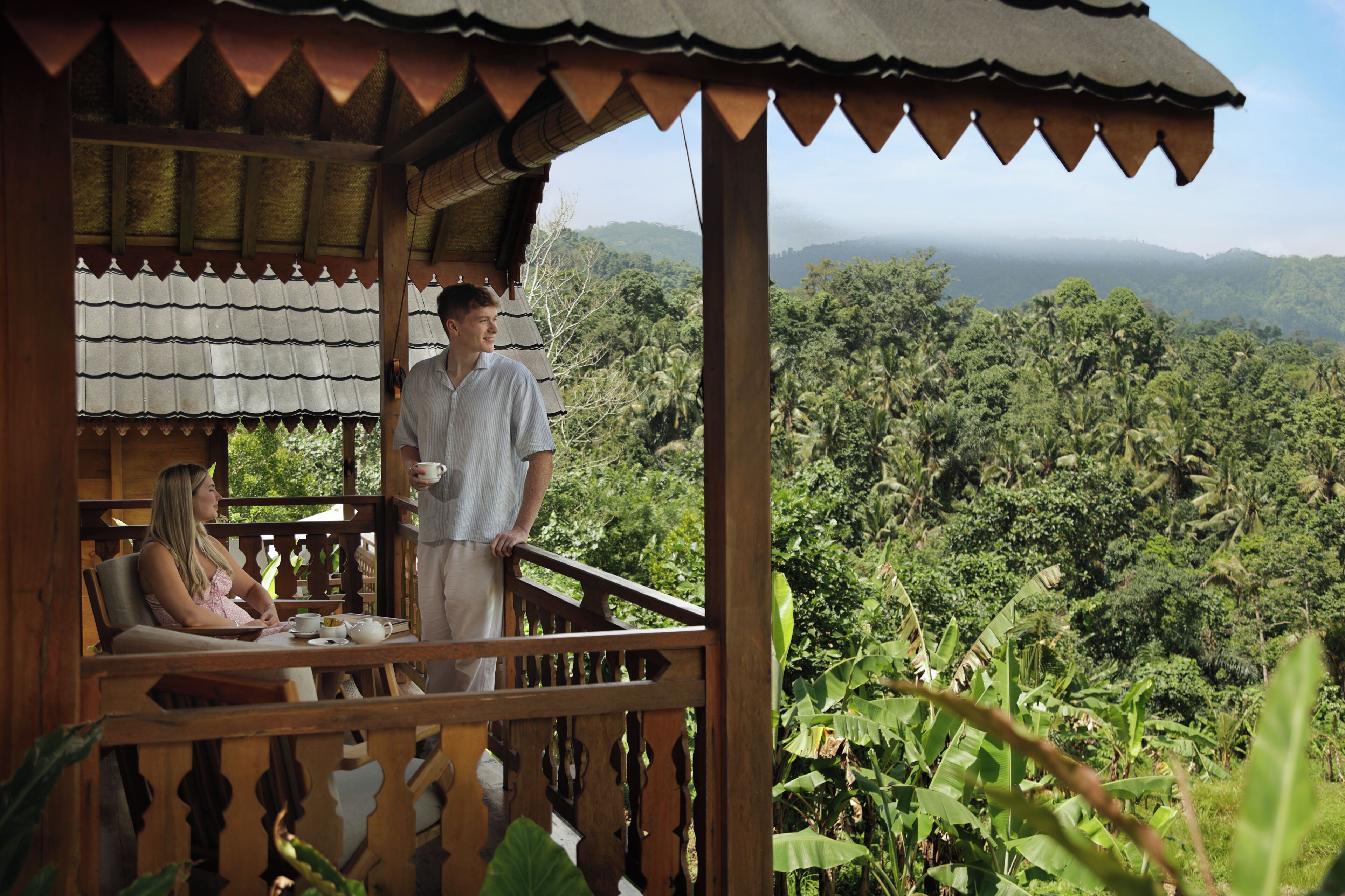 A wooden structure with a balcony overlooking a lush, green landscape.