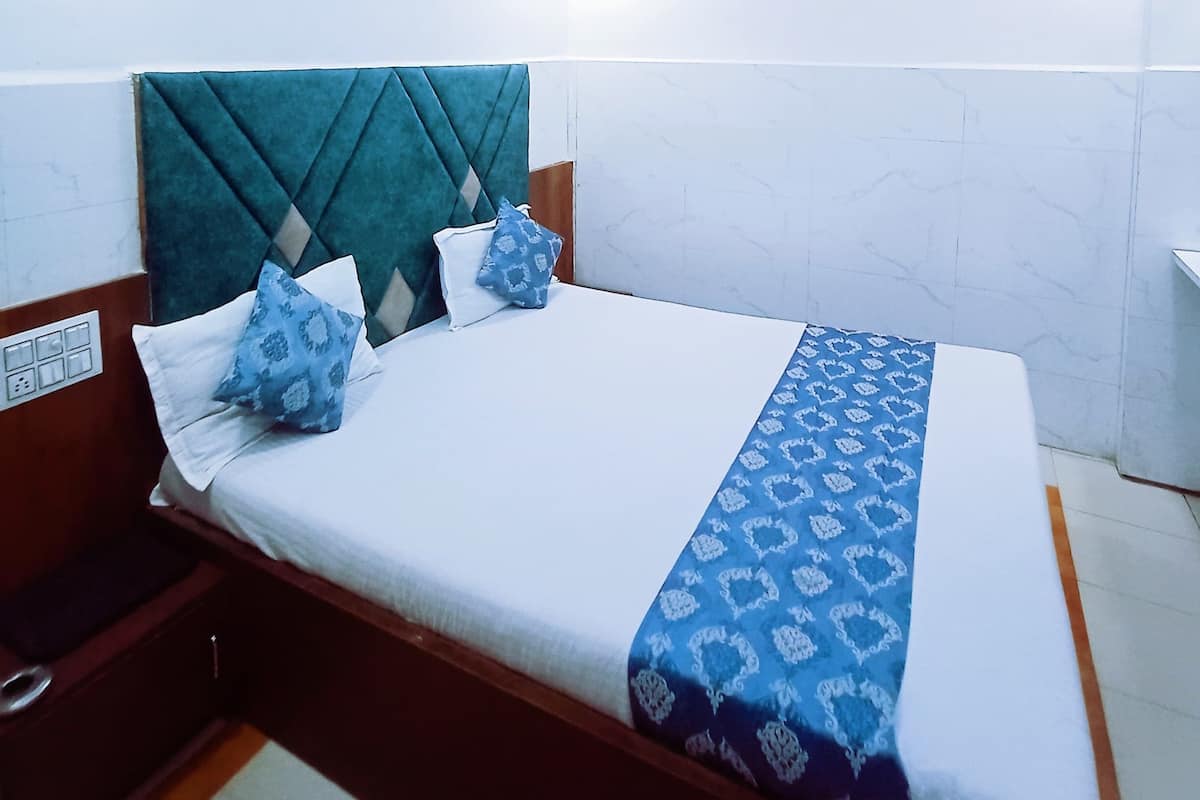A modern bedroom with a bed, a headboard, and a ceiling light fixture.