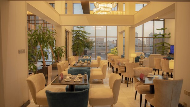 Un amplio comedor con techos altos y ventanas grandes que ofrecen vistas a la ciudad.