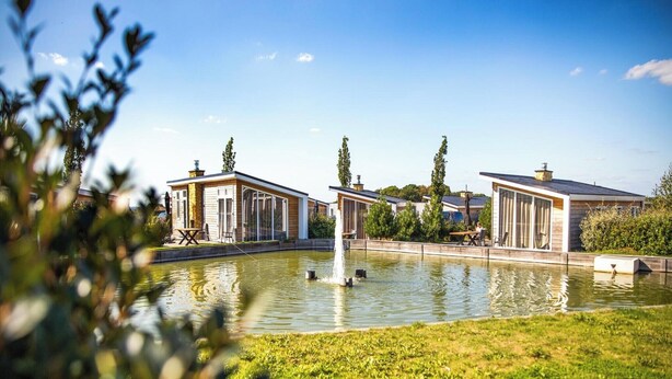 A row of modern, single-story houses with a central water feature, surrounded by greenery. - Chalet in Bemelen near Bemelerberg Reserve (Bemelen)