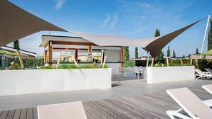 A rooftop terrace with sunshades, lounge chairs, and a dining area. - Holiday Home Bemelen near Nature Reserve (Bemelen)