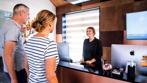A reception desk with a laptop, a cash register, and a payment terminal.