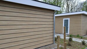 A modern building with horizontal wooden siding and a small door.