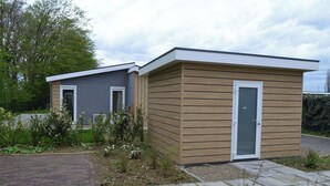 A modern two-story house with a grey exterior and a brown wooden extension.