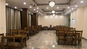 Ένας ευρύχωρος χώρος με πολυέλαιο, ανεμιστήρες οροφής και ένα γυαλιστερό μαρμάρινο δάπεδο.