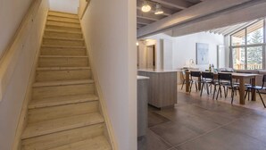 A wooden staircase leading to a modern kitchen with a dining area. - Apartment in La Rosière with Alpine Views (la rosiere montvalezan)