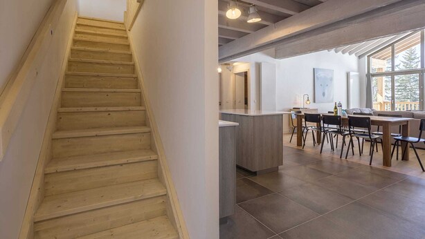 A wooden staircase leading to a modern kitchen with a dining area. - Apartment in La Rosière with Alpine Views (la rosiere montvalezan)