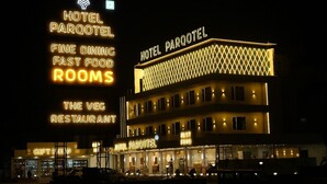 A hotel with multiple floors, illuminated signs for 'Hotel Parqotel', 'Fine Dining', 'Fast Food', and 'Rooms'. - HOTEL PARQOTEL (Vapi)