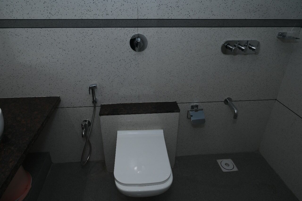 Une petite salle de bain moderne avec des toilettes blanches, une douche et un lavabo.