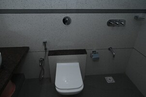 Une petite salle de bain moderne avec des toilettes blanches, une douche et un lavabo.