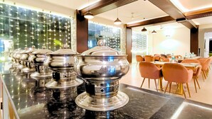 Een modern restaurant met een lange toonbank, meerdere bedieningspunten en oranje stoelen.