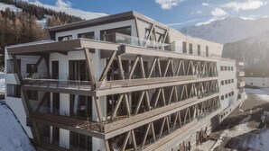 Un edificio moderno con varios pisos, ventanas amplias y un balcón.