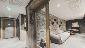 Una sala de estar moderna con una pared de piedra, un sofá y una puerta de madera.