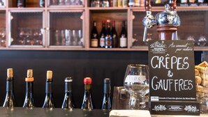 A bar with a sign reading "CRÈPES & GAUFFRES" and a selection of wine bottles. - Apartment in Chantemerle with Family Ski Fun (Saint Chaffrey)